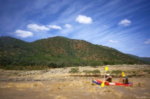 Two paddlers in a small inflatable canoe known locally as a "croc" navigate one of the calmer sections of the Tugela River.